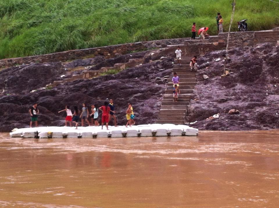 Laotian children rushing to meet the slowboat